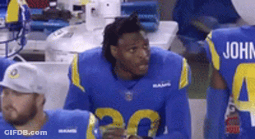Football Player In Blue And Yellow Uniform Sitting On Sidelines GIF