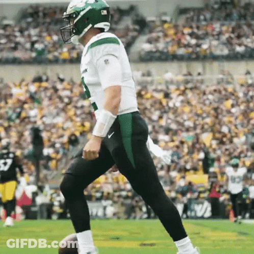 Football Player In Green Helmet Kicking Ball GIF
