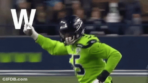 Football Player In Green Jersey Holding Letter W GIF