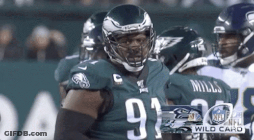 Football Player In Helmet Standing In Front Of Group GIF