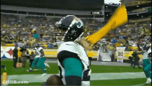 Football Player In Jaguars Uniform Holding Yellow Flag GIF