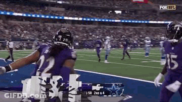 Football Player In Purple Uniform Celebrating Touchdown GIF