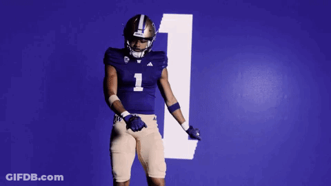 Football Player In Purple Uniform Dancing In Front Of Blue Wall Number 1 GIF