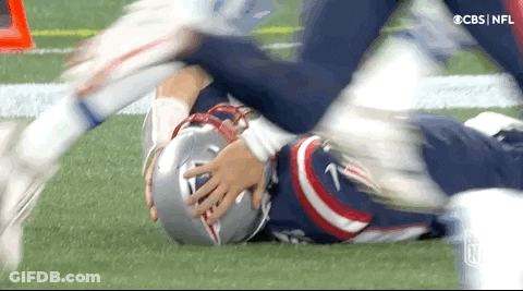 Football Player Lying On Ground Head In Hands GIF