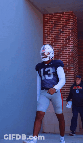 Football Player Number 13 In Front Of Brick Wall GIF