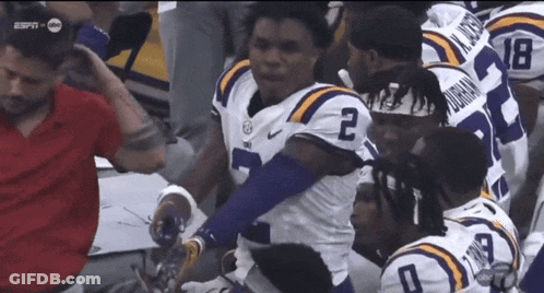 Football Player Number 2 Surrounded By Teammates GIF
