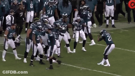 Football Player Number 21 On Field With Teammates GIF