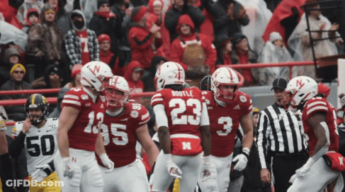 Football Player Number 23 Surrounded By Teammates GIF