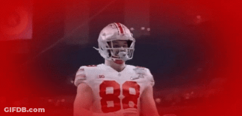 Football Player Number 23 Surrounded By Teammates GIF