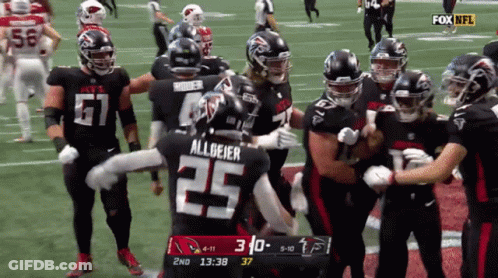Football Player Number 25 Surrounded By Teammates GIF