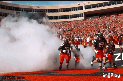 Football Player Number 27 Runs Out Of Tunnel GIF