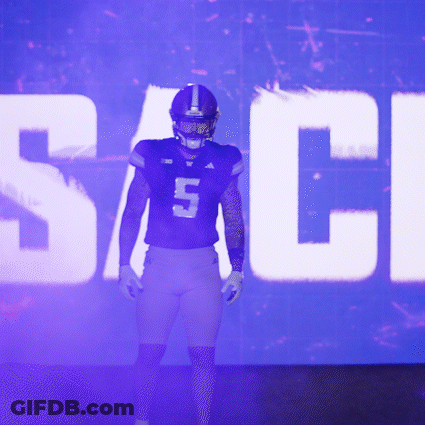 Football Player Number 5 Standing In Front Of Large Screen GIF
