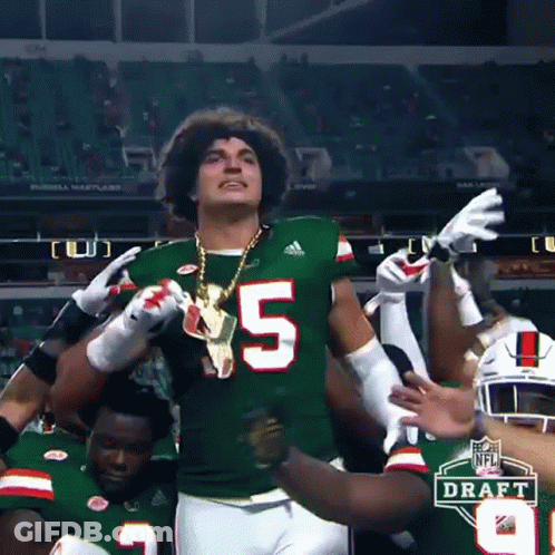 Football Player Number 5 Surrounded By Teammates GIF