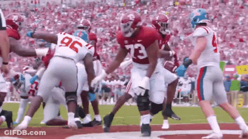 Football Player Number 73 Surrounded By Players GIF