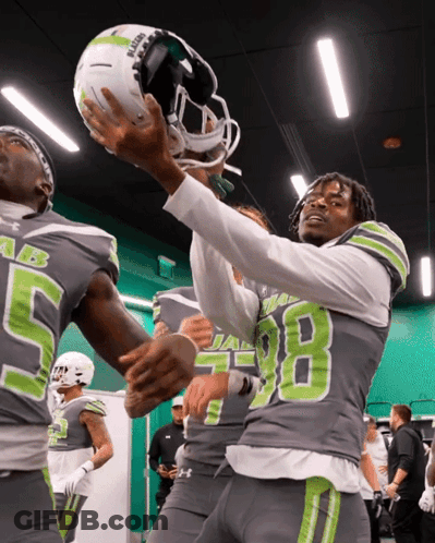 Football Player Number 98 Holding Helmet Above Head GIF