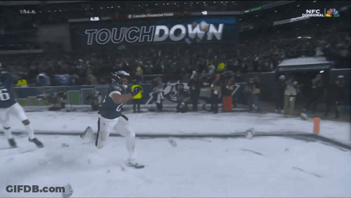 Football Player Running In Snow In Front Of Touchdown Sign GIF