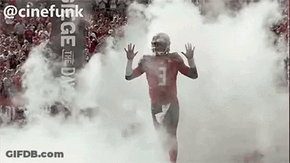 Football Player Running Through Cloud Of Smoke GIF