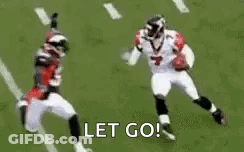 Football Player Running Toward Player On Ground GIF