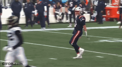 Football Player Running While Another Watches GIF