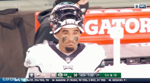 Football Player Sitting In Front Of Gator Sign GIF