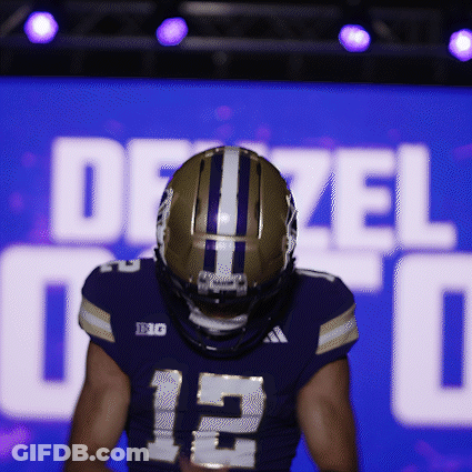 Football Player Standing In Front Of Dezel Sign GIF
