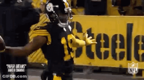 Football Player Standing In Front Of Yellow Sign GIF