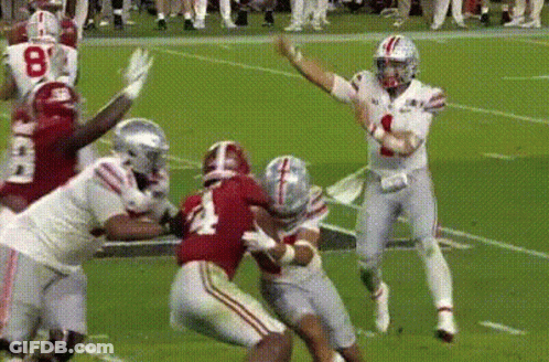 Football Player Throwing Pass While Being Tackled GIF