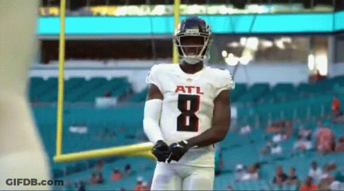 Football Player Throws Ball On Field With Crowd GIF
