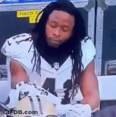 Football Player With Dreadlocks Signing Glove GIF