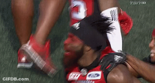Football Player With Red Face Paint Being Helped Off GIF