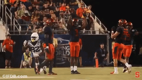 Football Players Celebrating Touchdown Under Banner Saying Aping World GIF