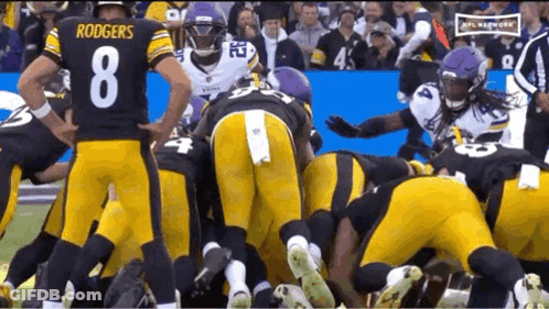 Football Players Huddled Including Rodgers GIF