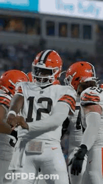 Football Players Huddled On Field GIF