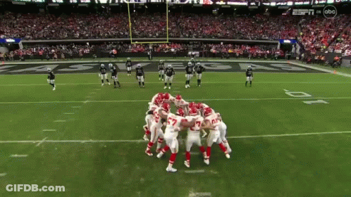 Football Players Huddled Together On Field GIF