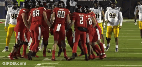 Football Players Huddled Together On Field GIF