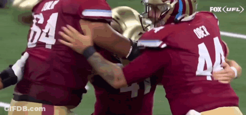 Football Players Hugging On Field GIF