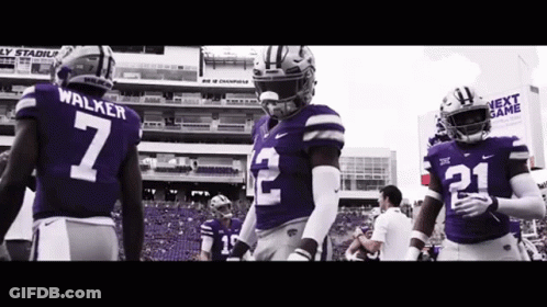 Football Players In Purple Uniforms Standing On Field GIF