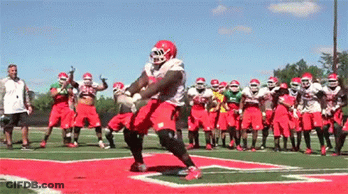 Football Players On Field One In Red Helmet GIF