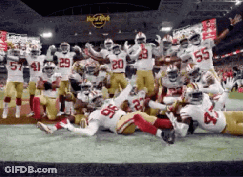 Football Players Posing In Front Of Hard Rock Cafe GIF