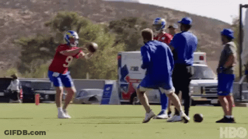 Football Players Practicing On Field With People Watching GIF