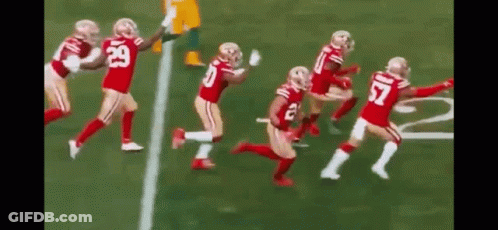 Football Players Running Across Field GIF