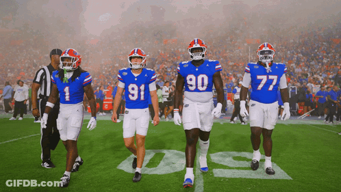 Football Players Running On Field With Flames GIF