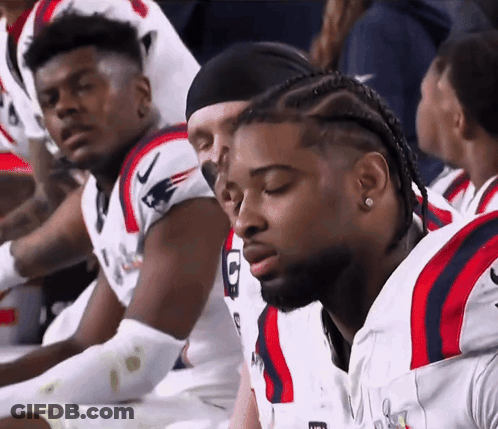 Football Players Sitting In Row With Letter G Jersey GIF