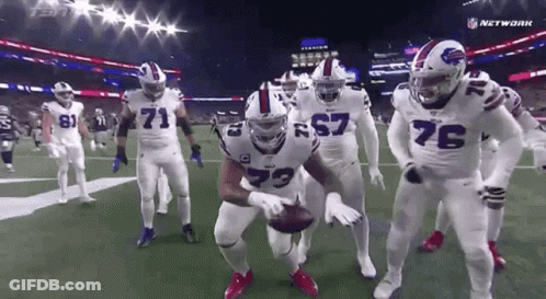 Football Players Standing On Field Holding Ball GIF