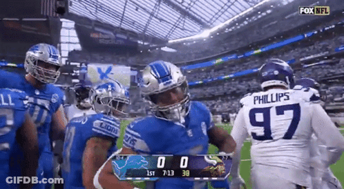 Football Players Standing On Field With Scoreboard GIF