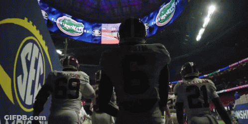 Football Players Walking Past Gators Sign GIF