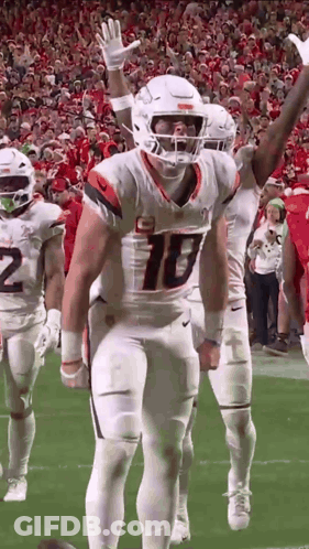 Football Players With Arms In Air On Field GIF