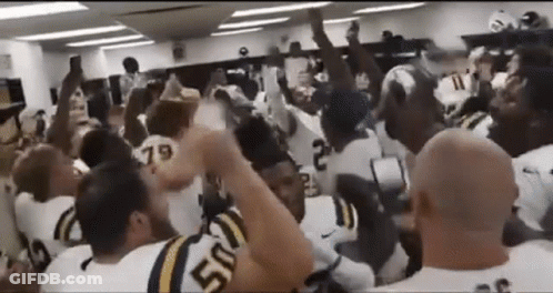 Football Players With Hands In The Air In Locker Room GIF