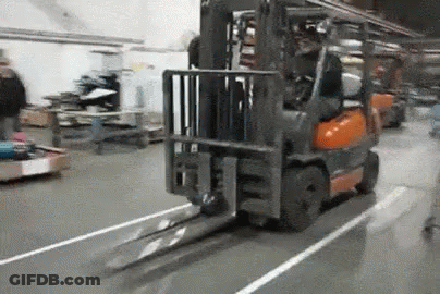 Forklift Driving Down Warehouse Floor GIF