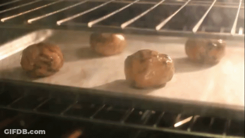 Four Cookies Baking In Oven On Wax Paper GIF
